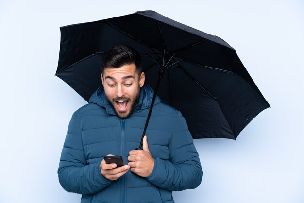 Man holding an umbrella over isolated wall