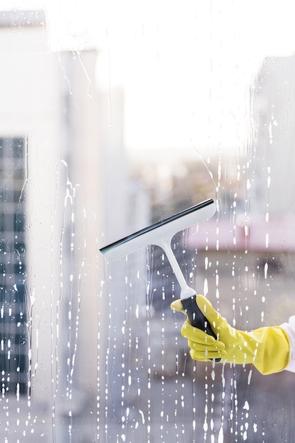 Photo man holding umbrella seen through wet glass window