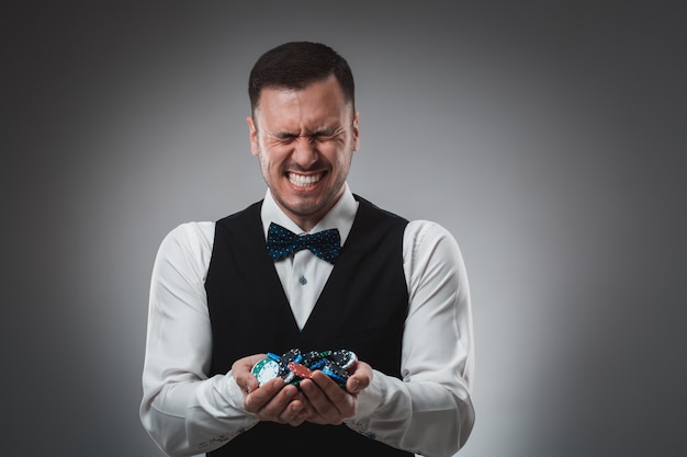 A man holding up poker chips. Poker