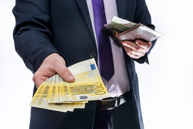 Man holding wallet and offering euro banknotes