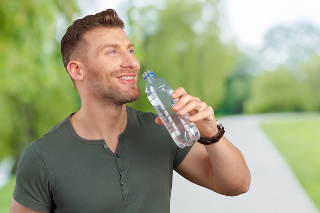 Uomo che tiene la bottiglia d'acqua