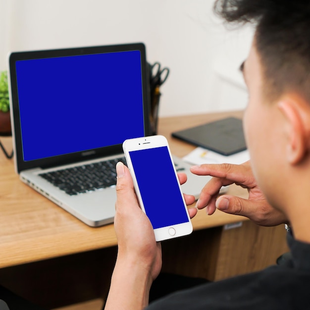 a man holding a white phone with a blue screen on it.
