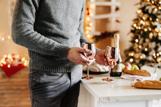 Uomo che tiene i bicchieri di vino e champaigne