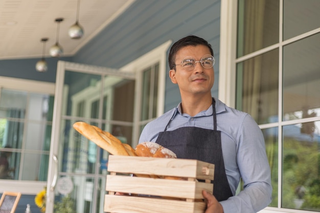 Man holding a wooden box containing bread Business owner concept