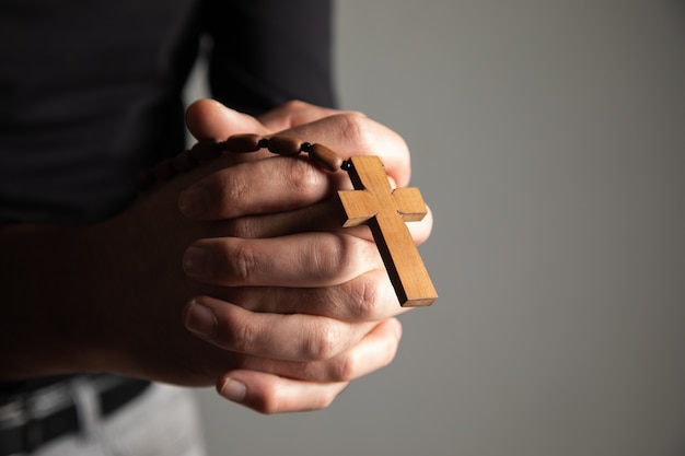 A man holding a wooden cross in his hand