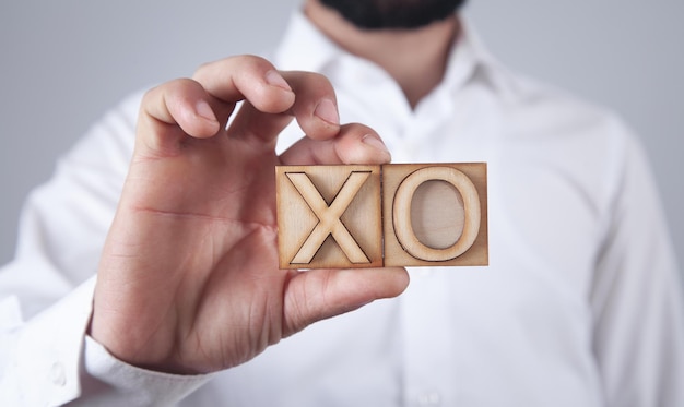 Man holding wooden X O symbols