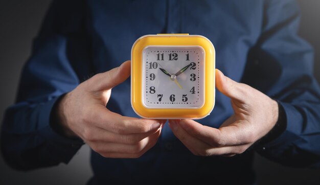 Man holding yellow clock Business Time management
