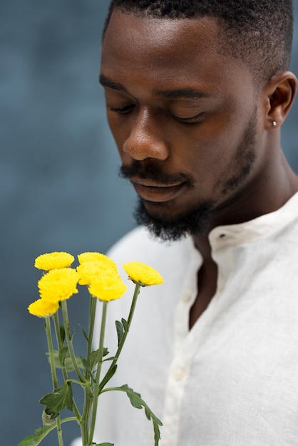 Foto uomo che tiene un colpo medio di fiori gialli