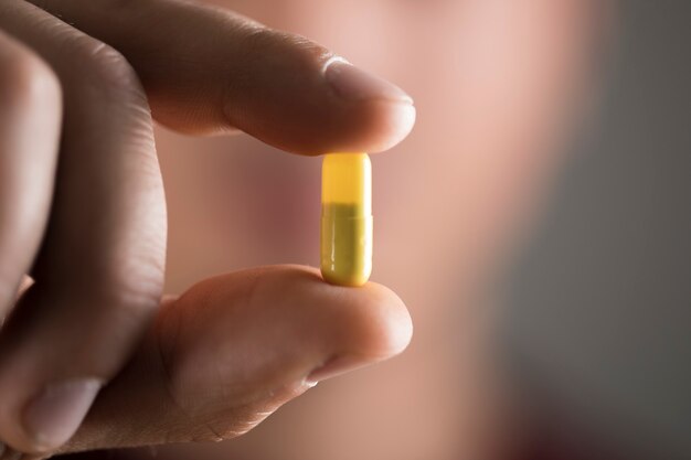 Man holding a yellow pill