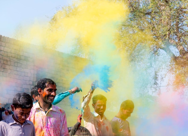 Photo a man holding a yellow smoke bomb in the air