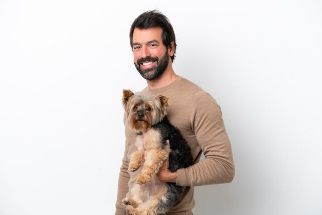 Man holding a yorkshire isolated on white background smiling a lot