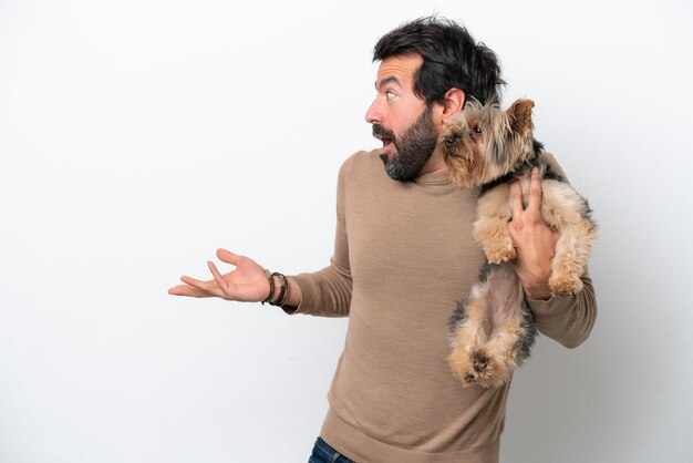 Man holding a yorkshire isolated on white background with surprise facial expression