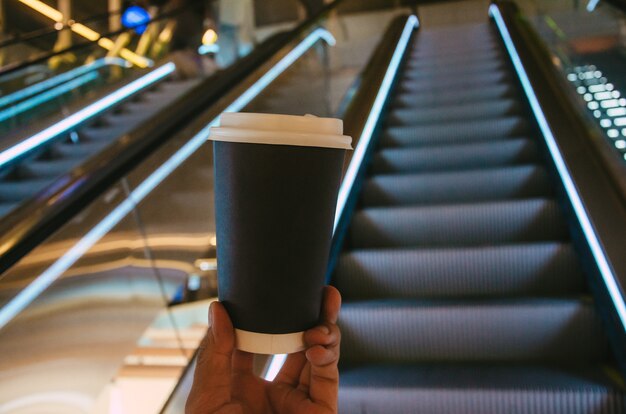 Man holds black cup of coffee in airport