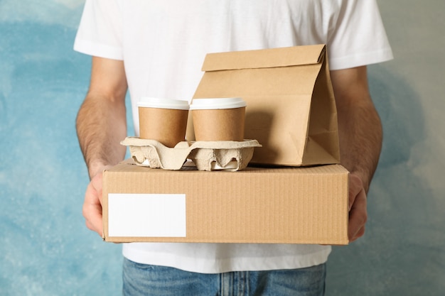 男は空白のボックス、コーヒーカップ、紙パッケージ屋内、テキスト用のスペースを保持しています。