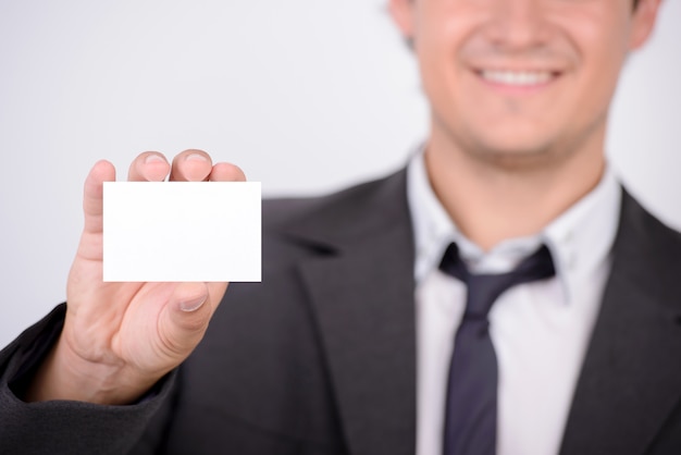 A man holds a blank card in his hands and smiles.