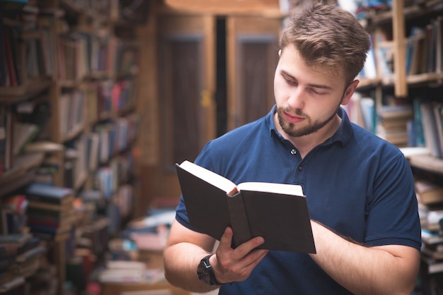 Man holds a book in his hands and reads it on a public library