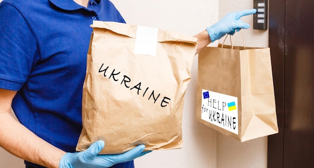 男はウクライナへの人道援助の箱を持っています
