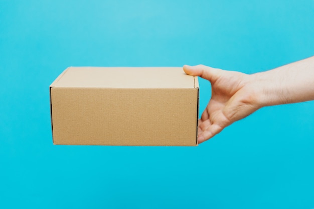 A man holds boxes in his hands on a blue background. Service delivery of goods. City delivery service.