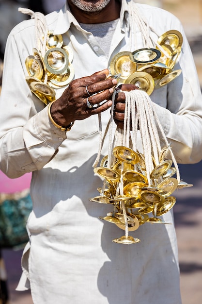 A man holds a bunch of bells in his hands India