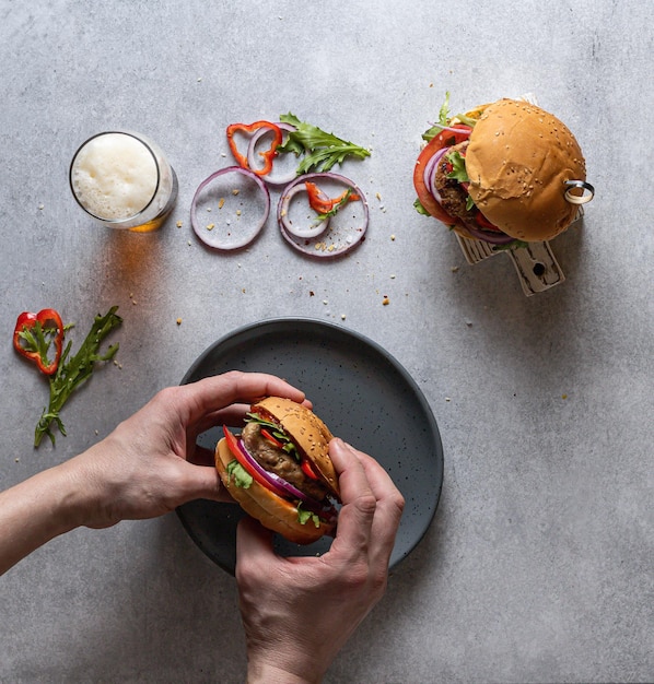 A man holds a burger in his hands top view