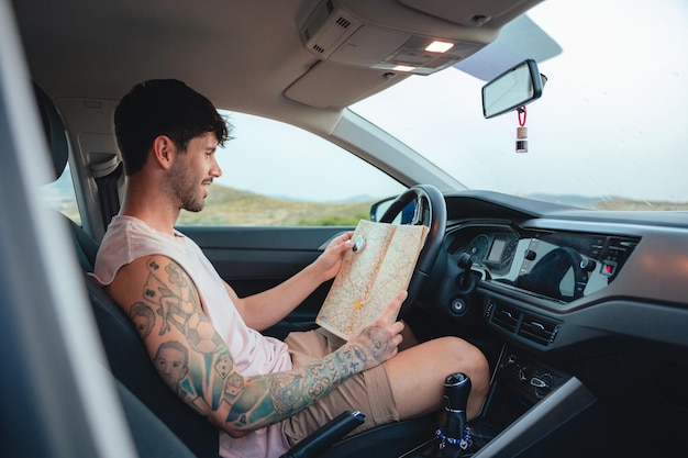 Man holds compass and map inside a car