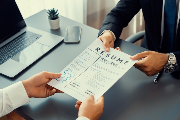 a man holds a document that says job job in a meeting room.