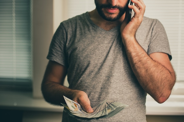 Photo a man holds dollars in his hands