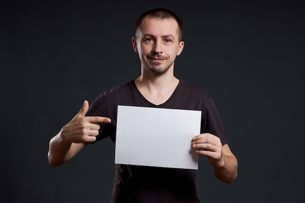 L'uomo tiene in mano un foglio di carta per poster vuoto.