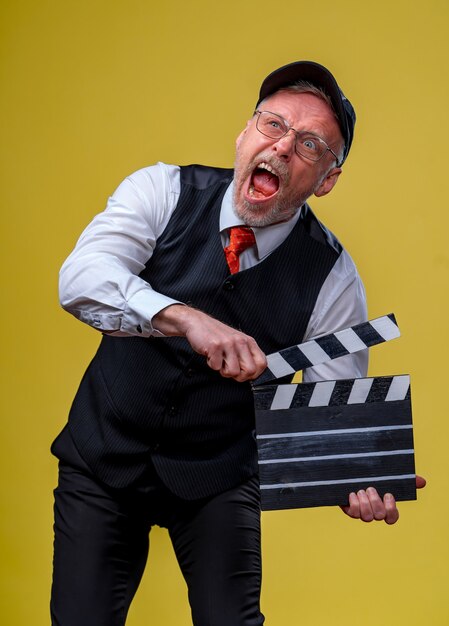 Man holds film flap. Male in cap with open mouth. Film directing. Film production. Human emotions. Close up.