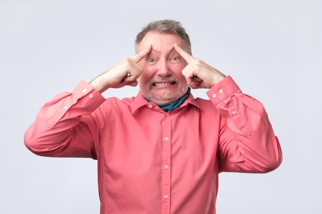 Man holds fingers on temples trying to remember