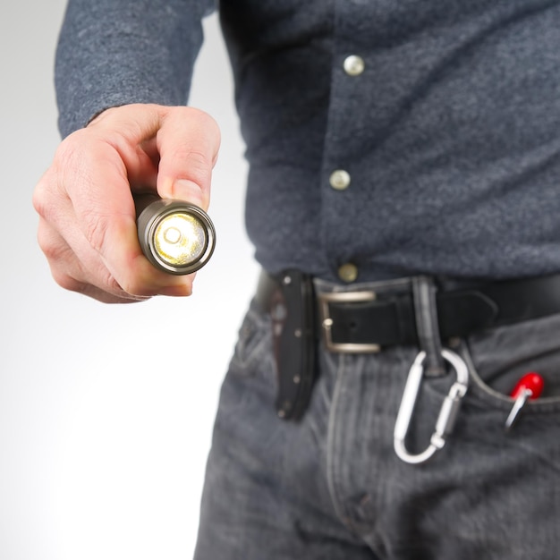 Man holds a flashlight in his hand item for camping and household life