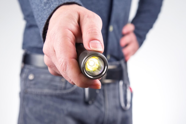 man holds a flashlight in his hand. item for camping and household life