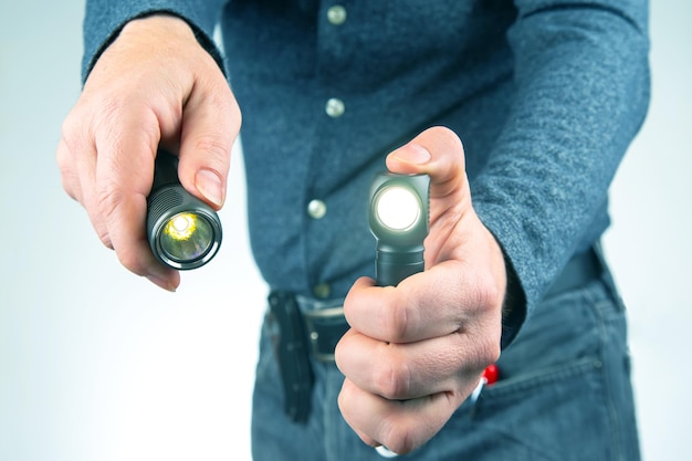 Man holds a flashlight in his hand item for camping and\
household life