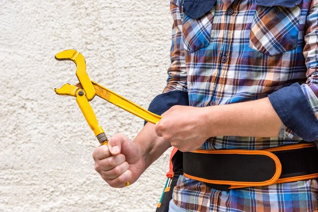 A man holds a gas key in his hands.