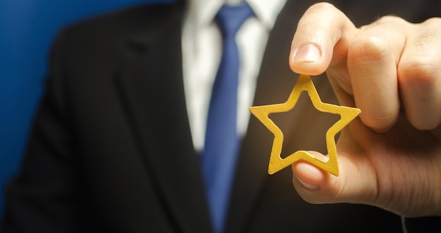 Photo man holds a golden star in his hand