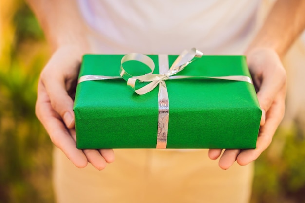 A man holds a green gift in his hands