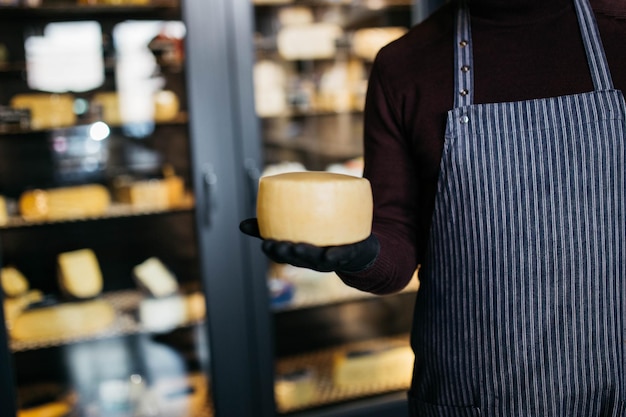 チーズ工場でチーズを手に持つ男性