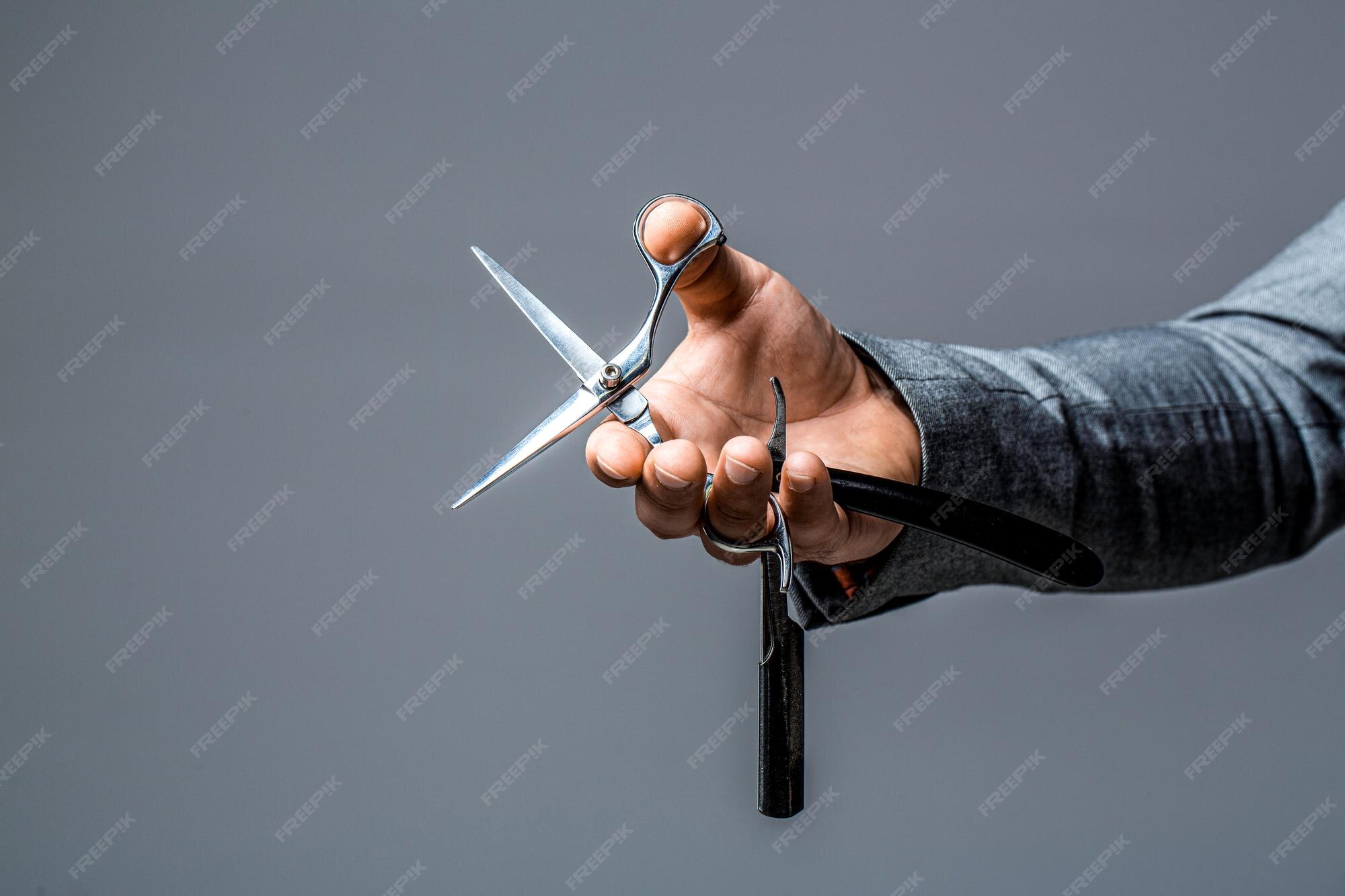 Premium Photo Man holds in his hand a vintage razor and scissors male