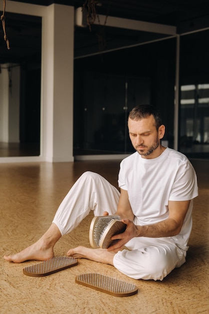 A man holds in his hands boards with nails for yoga classes