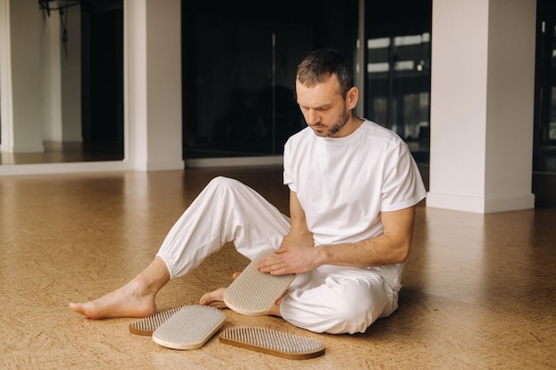 A man holds in his hands boards with nails for yoga classes