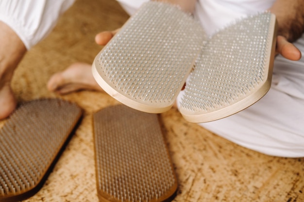 A man holds in his hands boards with nails for yoga classes