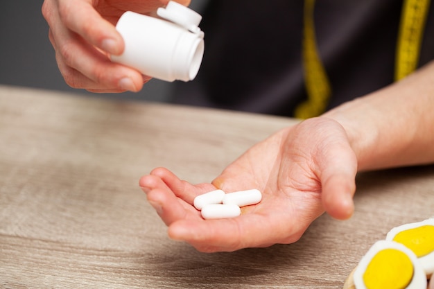 man holds in his hands a pill bio additive to the daily diet