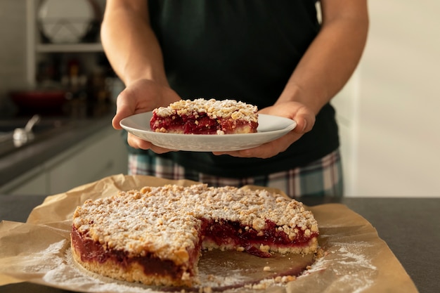 Man holds homemade plum cake in his hands