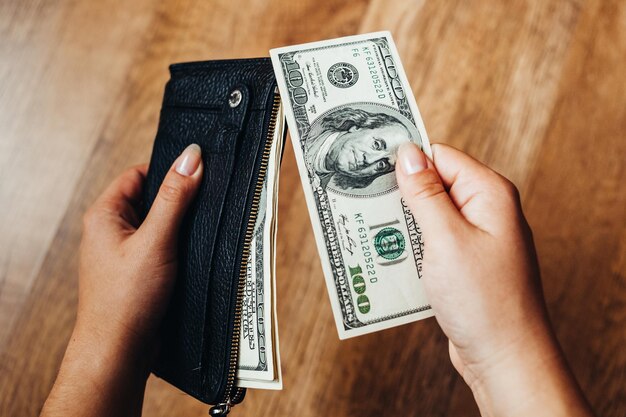 a man holds hundreds of dollars