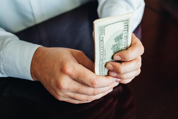 a man holds hundreds of dollars