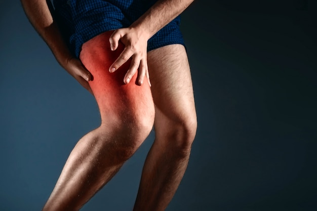 the man holds on to the knee, the pain in the knee