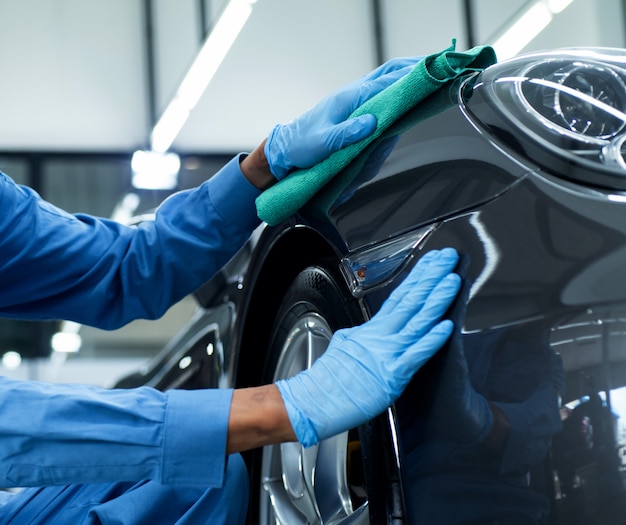 Photo man holds the microfiber in hand and polishes the car