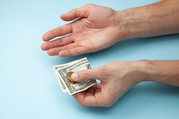 Man holds money in his hands and one palm up.