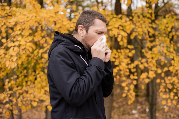 A man holds a napkin near his nose