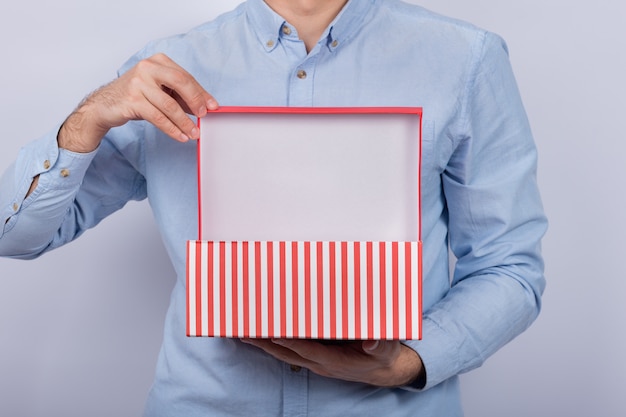 Man holds open the festive box. Gift box in men's hands. Front view